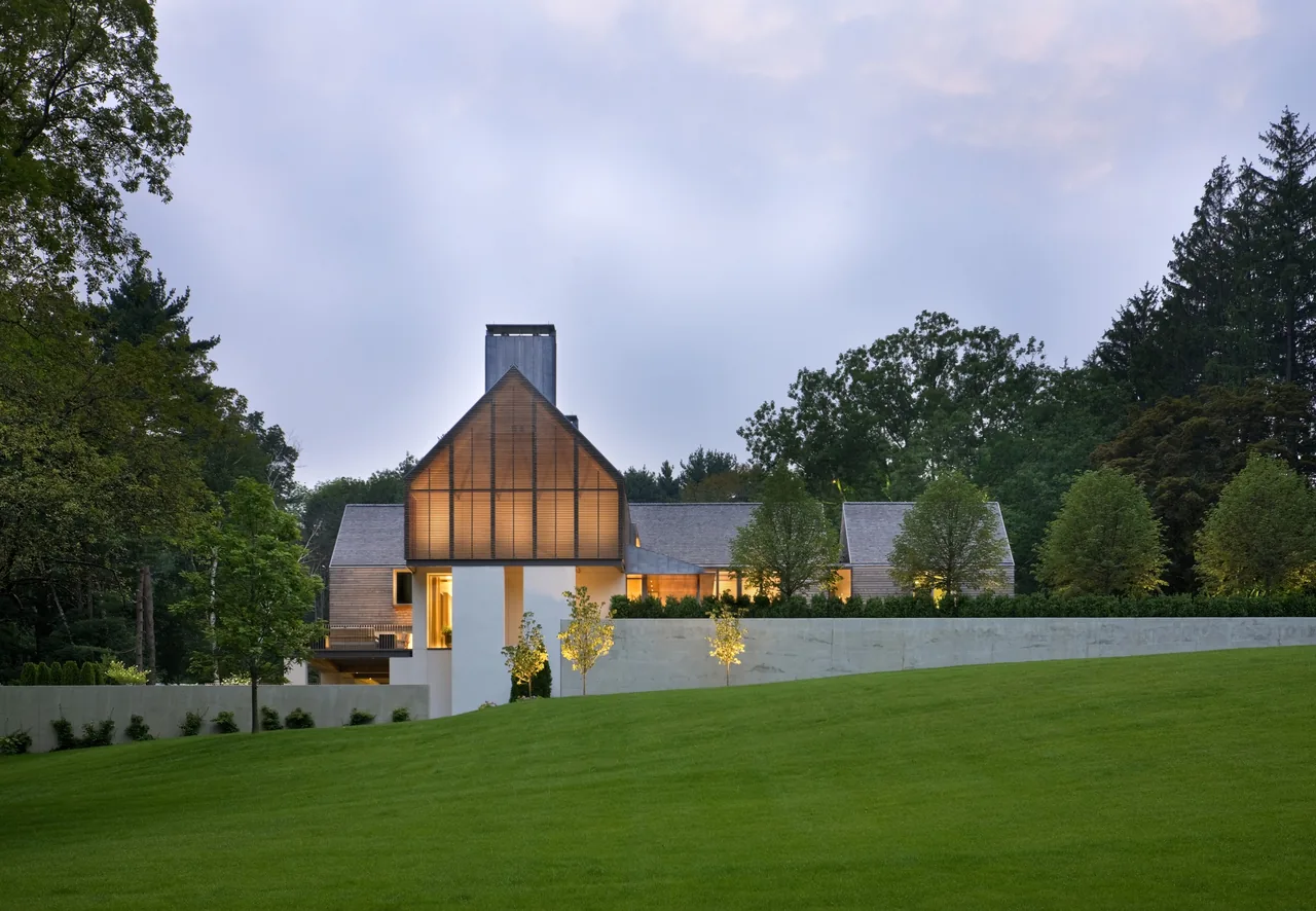 Exterior rear view of 44PL featuring a large glass gable and a sloped roof, set in a landscaped yard.