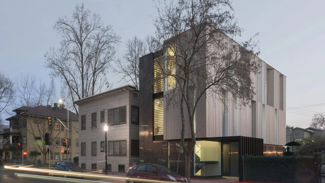 The Flex House by Johnsen Schmaling Architects features vertical wood siding and narrow windows in a multi-story design.