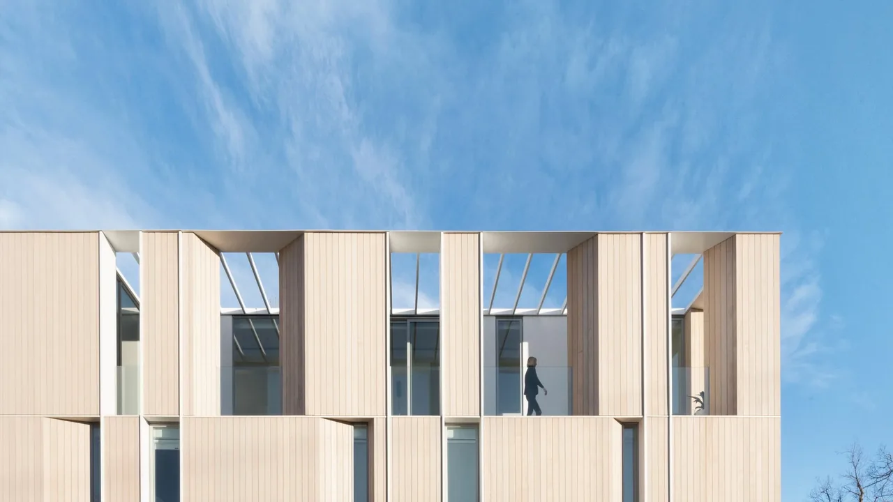 Multi-story modern house featuring vertical wood siding and a glass roof pergola on the top floor.