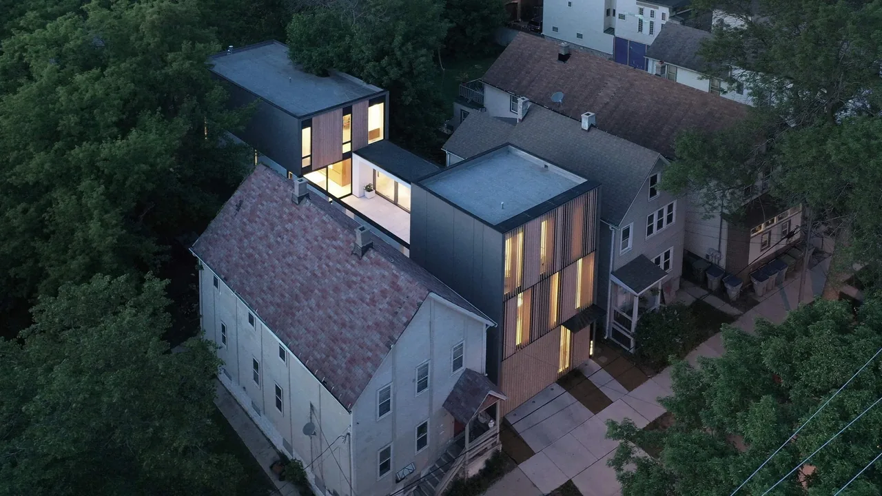 Curtain House by Johnsen Schmaling Architects features a modern urban infill design with vertical wood slats and flat roofs.
