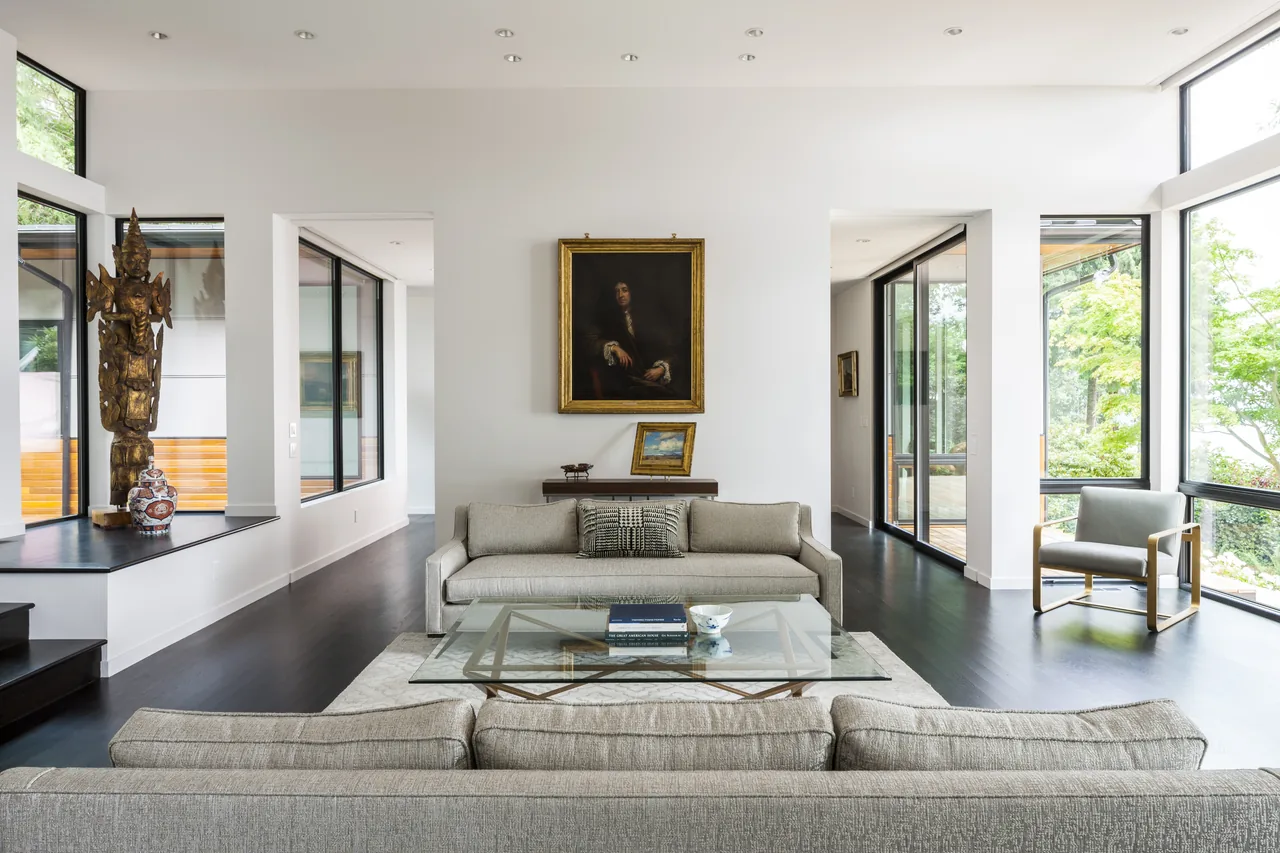 Living room with floor-to-ceiling glazing and a glass coffee table in a modern-style Sunrise House by Johnson Squared Architecture + Planning.