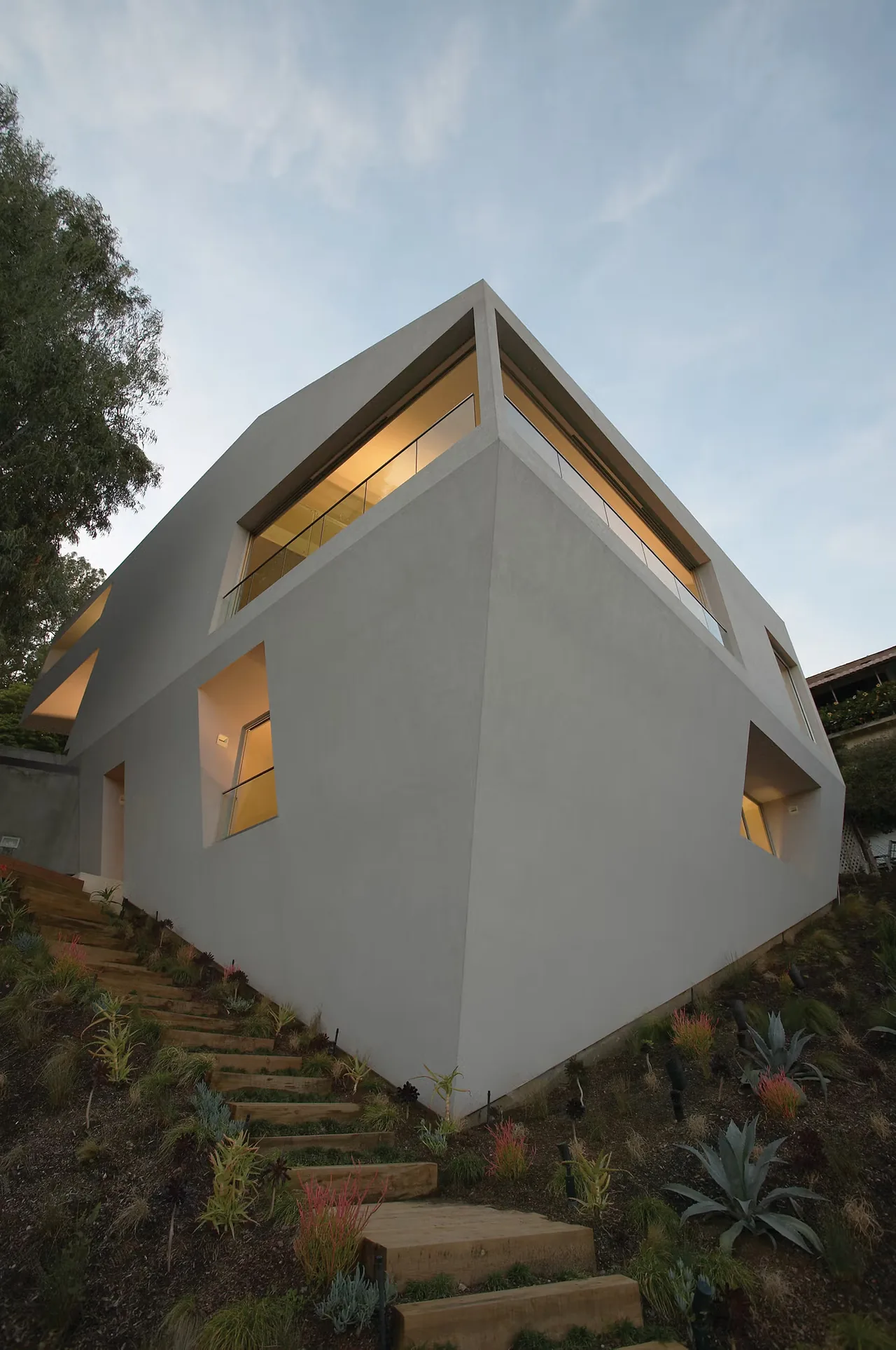 Hill House in Los Angeles by Johnston Marklee features angular concrete walls and a cantilevered upper floor with large windows.