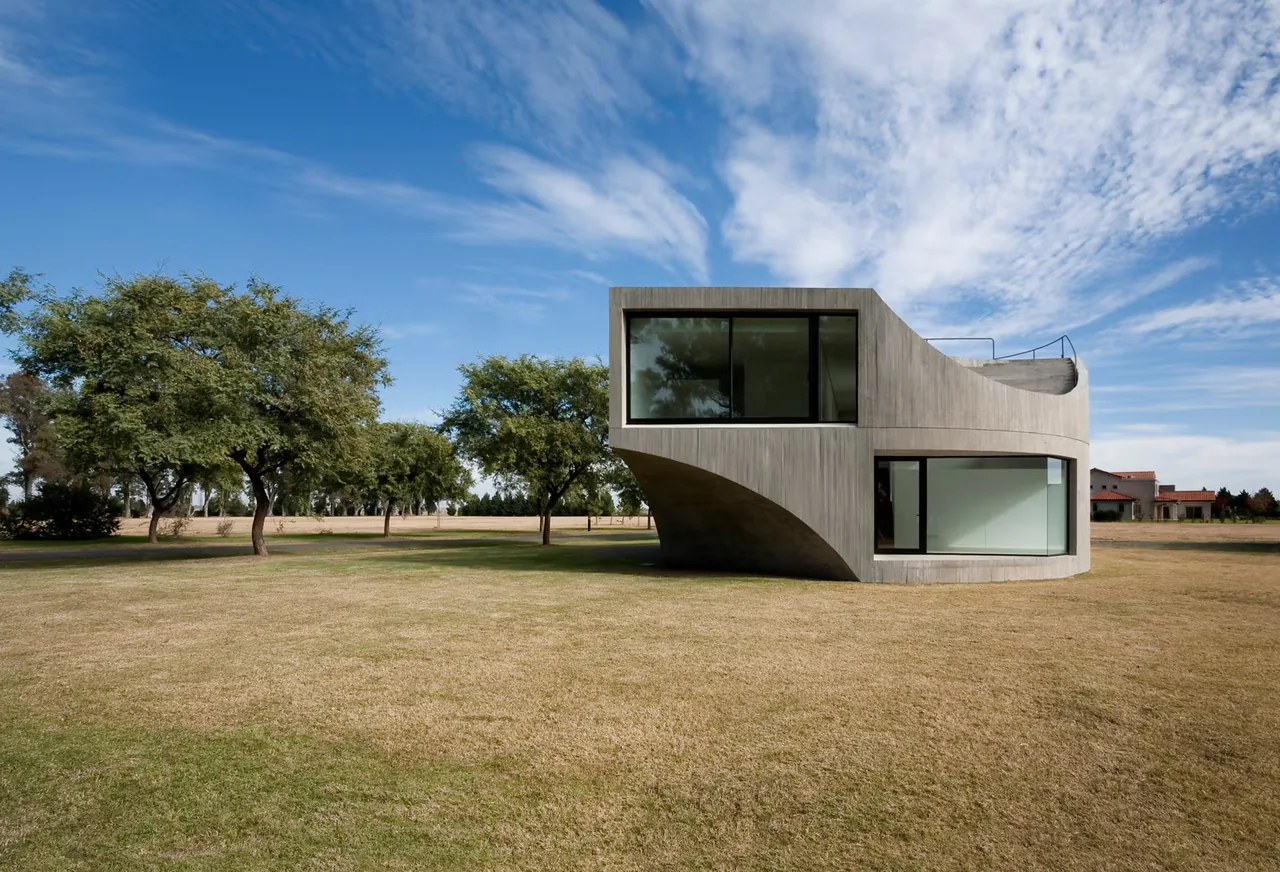 View House by Johnston Marklee features a curved concrete facade with large black-framed windows.