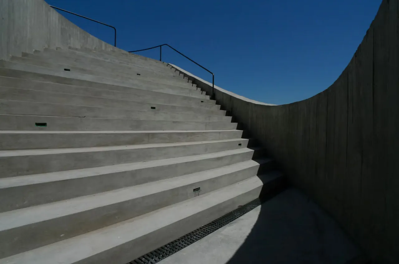 Concrete exterior stairs with embedded lighting and black metal railings in the View House project.