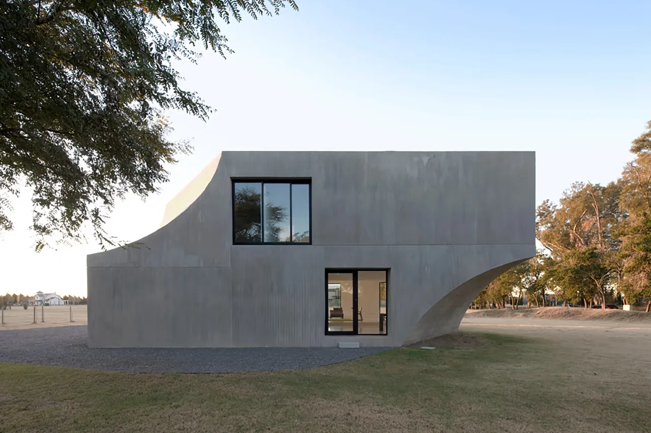 View House features a curved concrete facade with large window openings and a cantilevered upper level.