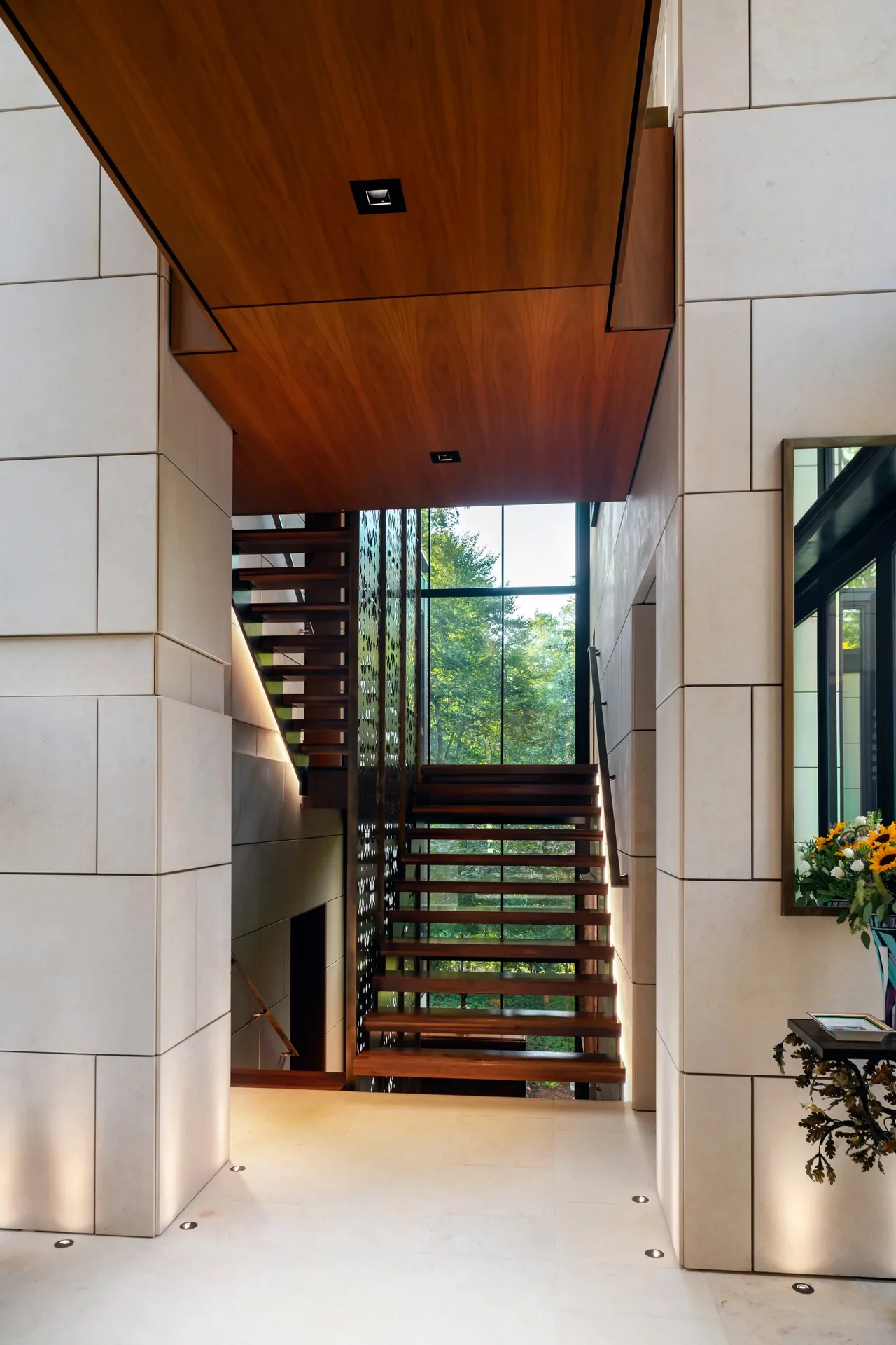 Modern stairwell featuring floating wood steps and a large floor-to-ceiling window providing natural views.