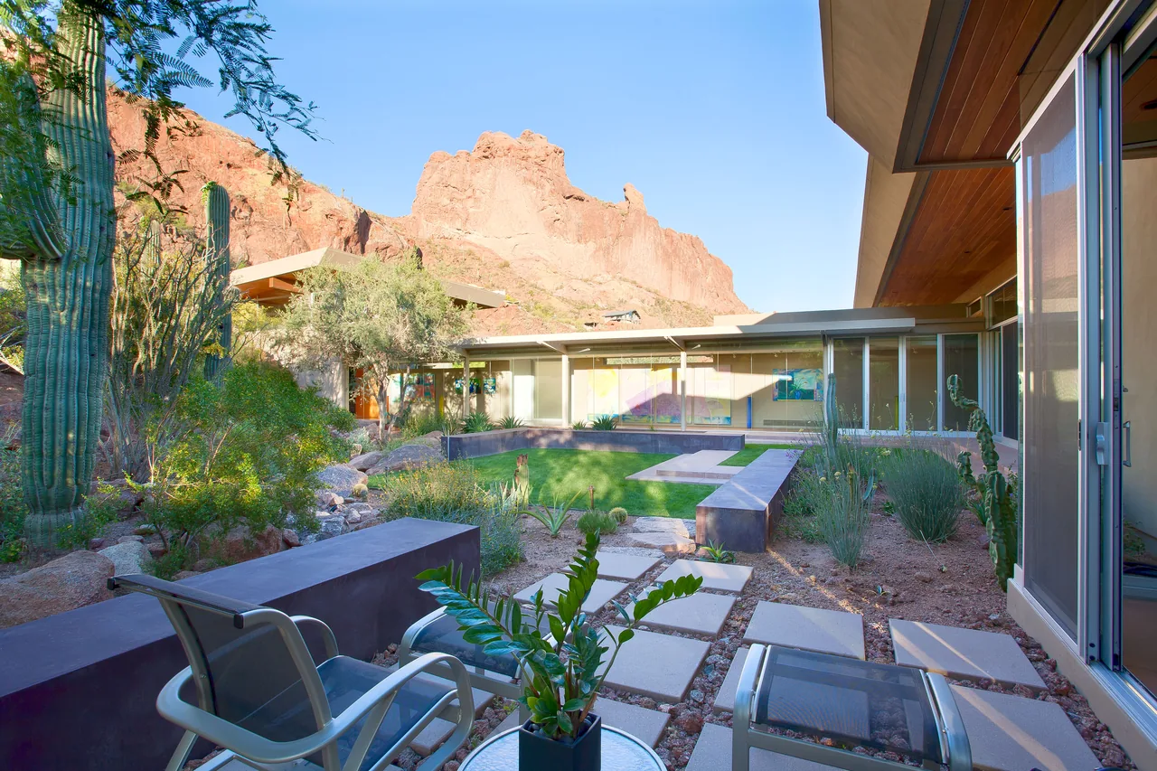 Outdoor courtyard of the Monks Shadow Residence with desert landscaping and direct views of rocky mountain formations.