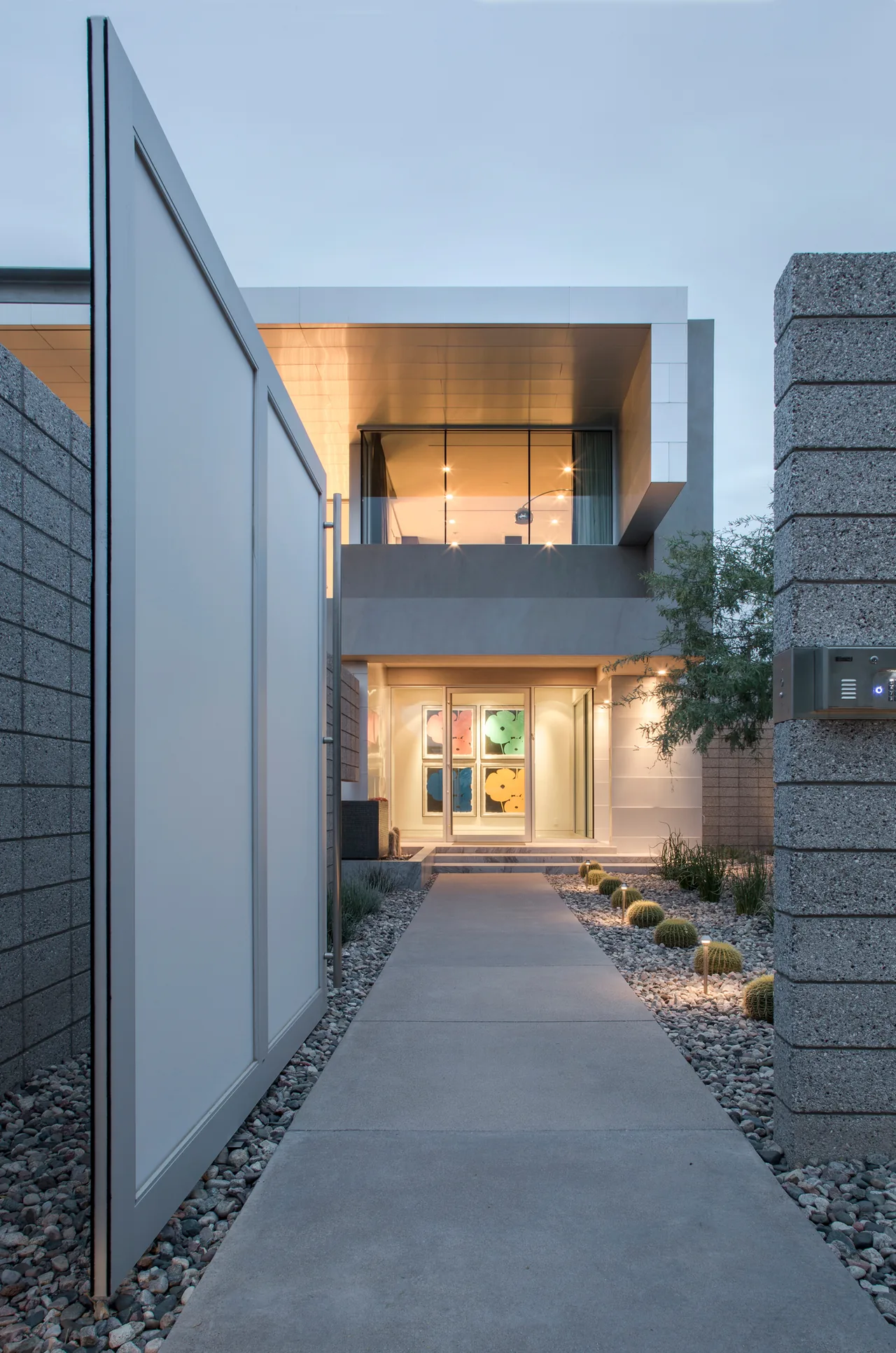 Birds Nest Residence entrance features concrete walkway, glass doors, and a cantilevered balcony above.