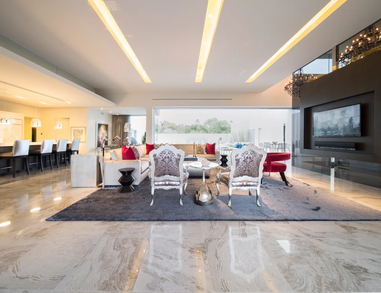 Birds Nest Residence living room with large glass window wall and connected kitchen bar area.