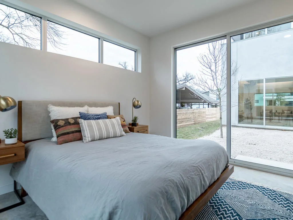 Modern bedroom features include clerestory windows and a sliding glass door opening to a courtyard.