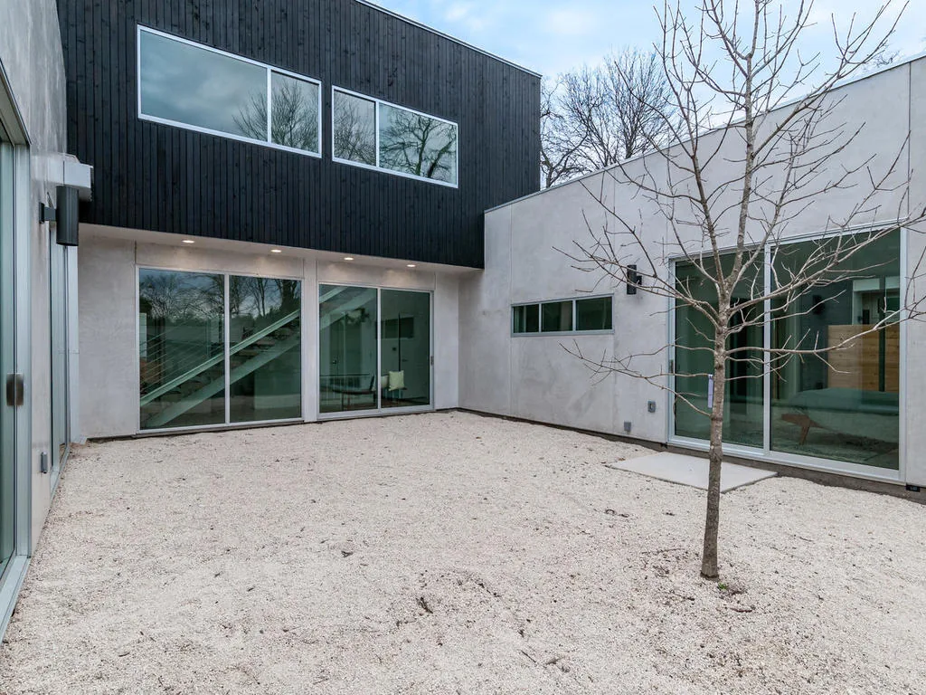 Modern courtyard with gravel and a small tree at 410postrd by KRDB in Austin.
