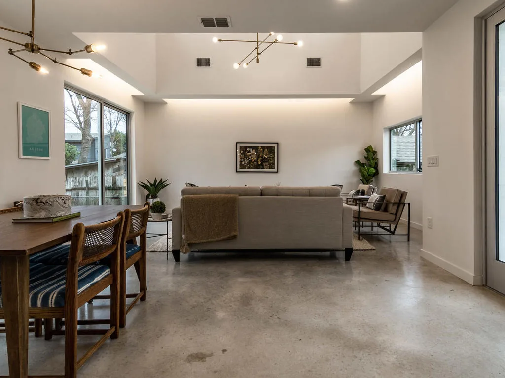 Interior shot of a living room with modern furnishings, concrete floors, and clerestory windows providing natural light.