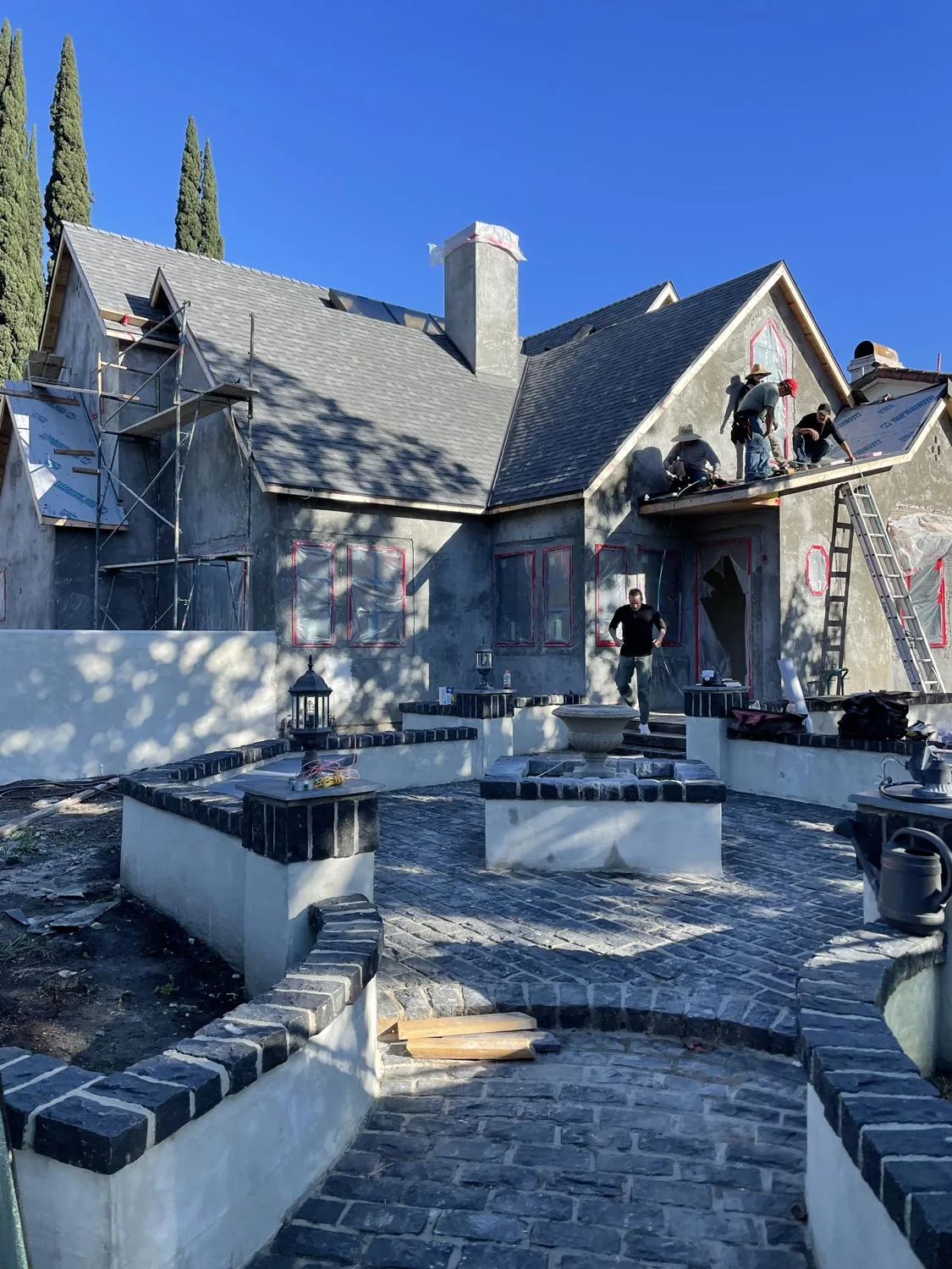 Clybourn Manor exterior in mid-construction showing stone paving and courtyard walls with black brick accents.