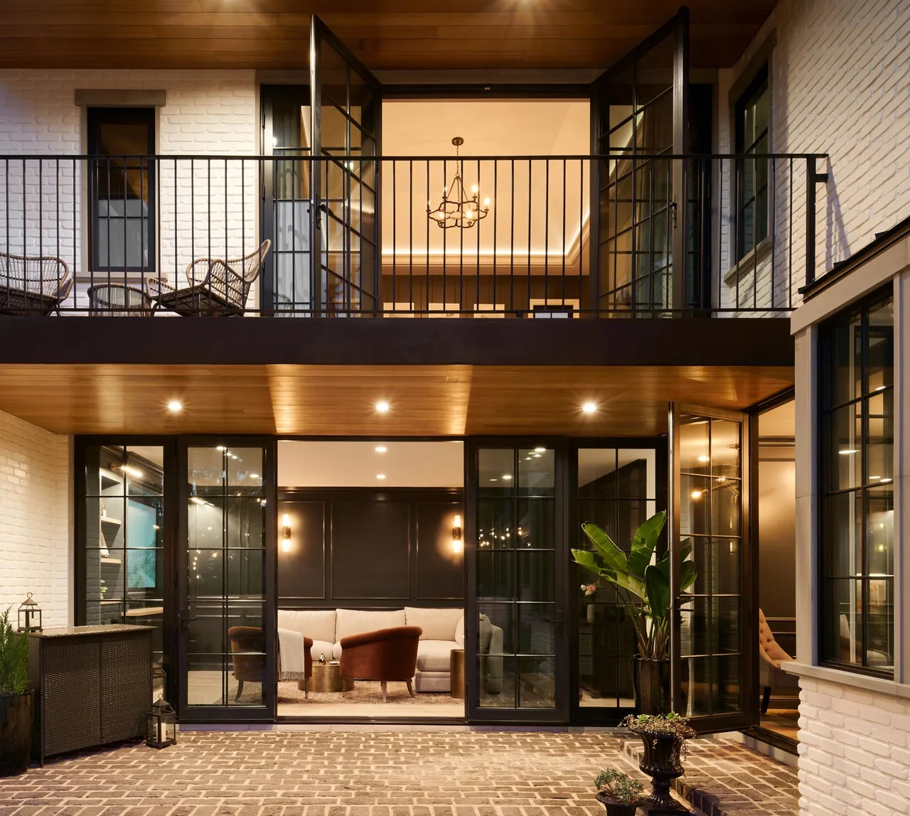 Nighttime look at Clybourn Manor's outdoor patio and upper balcony with seating and lighting.