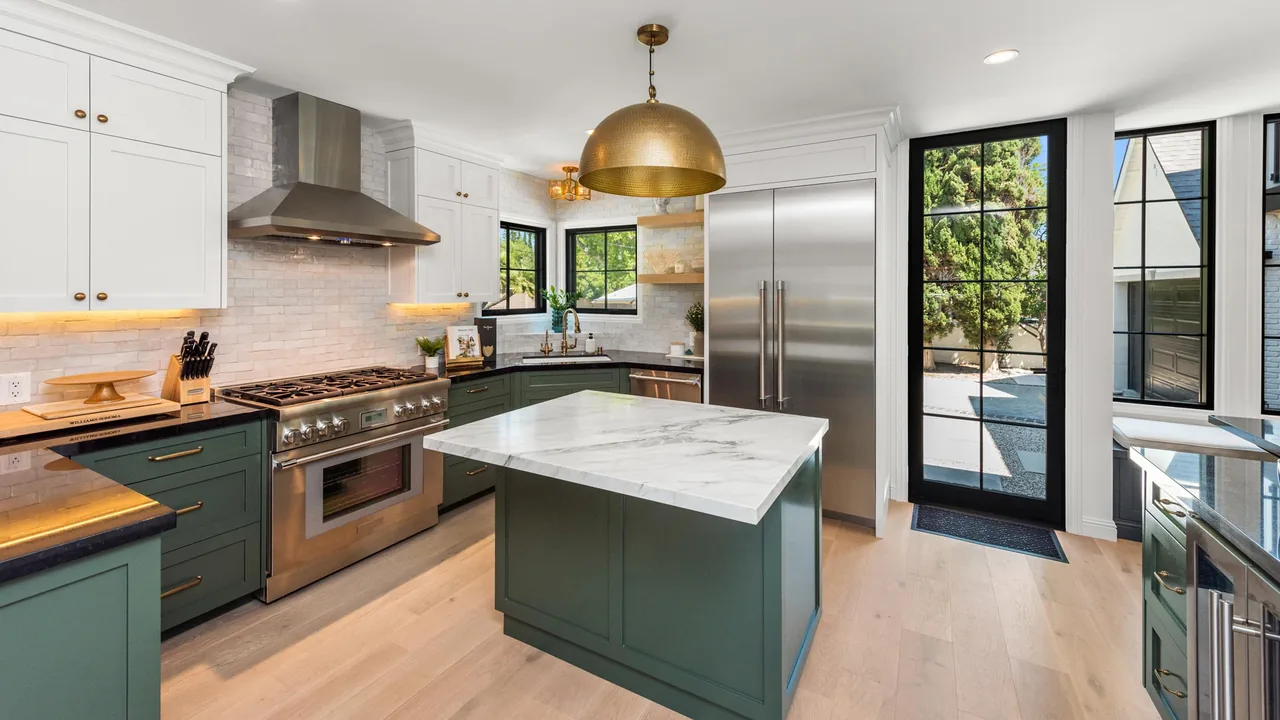 Kitchen features a marble island, stainless steel appliances, and black-framed windows and door opening to the courtyard.
