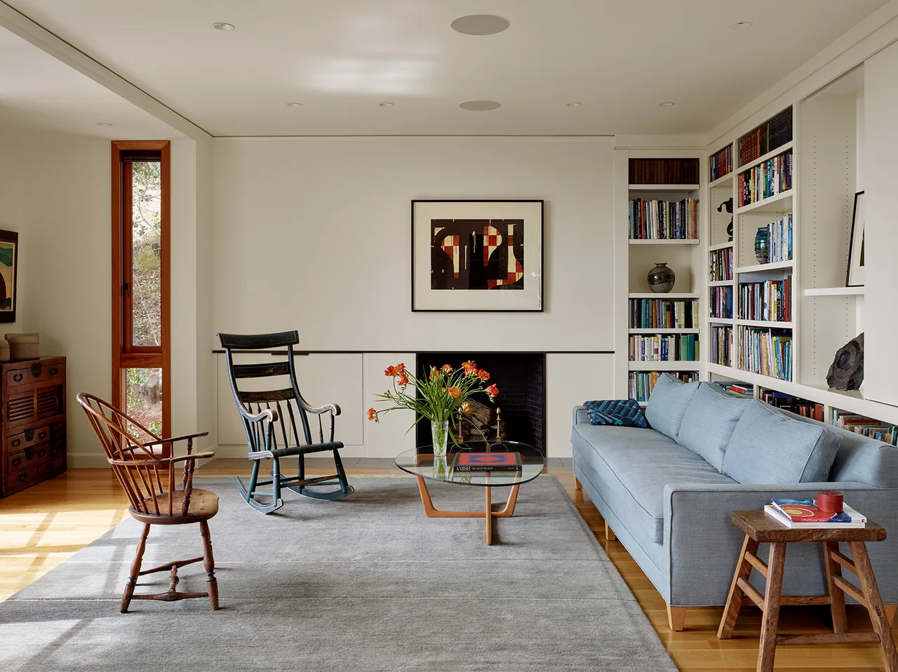 Living room featuring built-in bookshelves, a fireplace, and wooden furniture in a modern style.