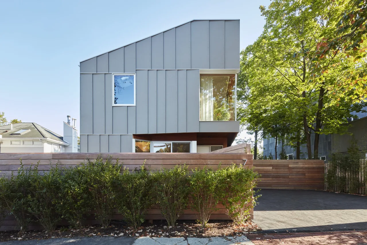 House II by Kyu Sung Woo Architects features a metal-clad two-story design with large windows and a wooden privacy fence.