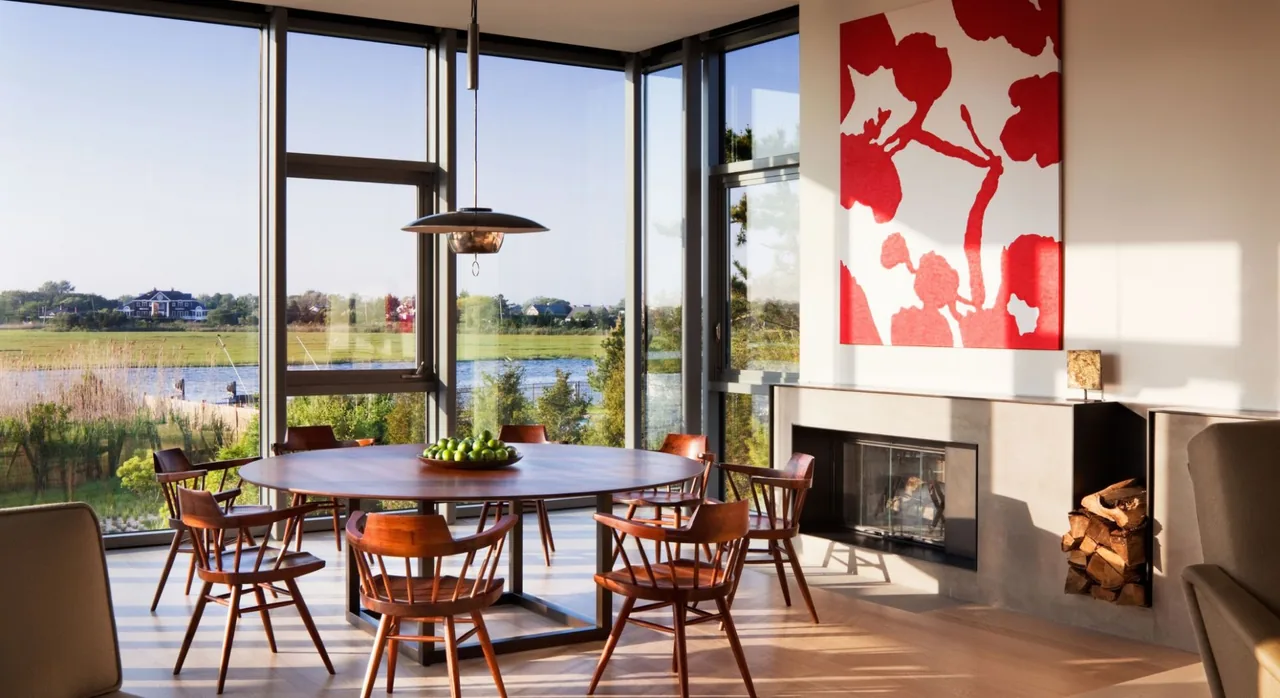Bay House dining room with floor-to-ceiling glazing offers views of the water, designed by Leroy Street Studio.