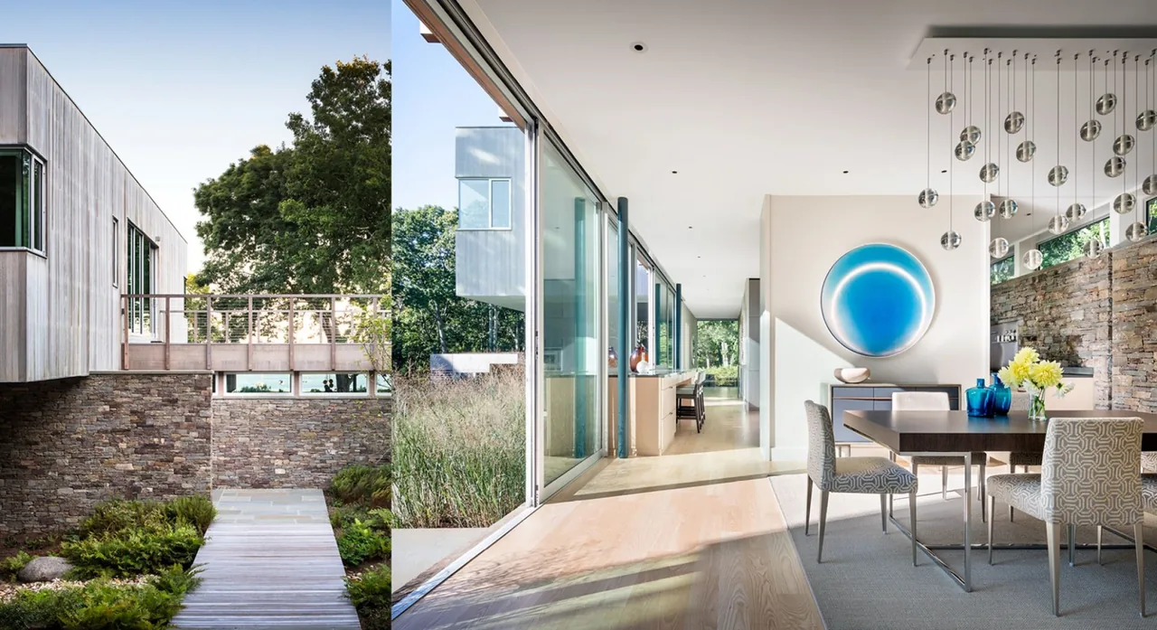 Hill House features an indoor dining space with floor-to-ceiling glazing and a stone retaining wall visible outside, in New York.
