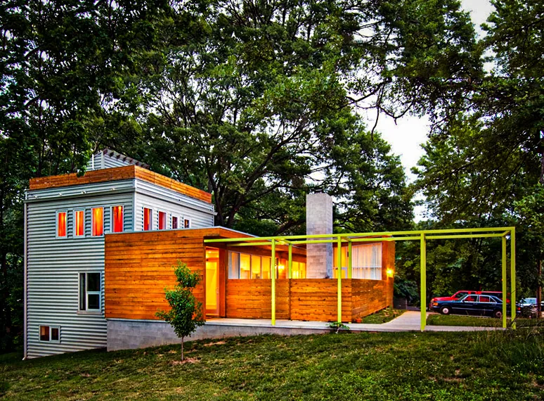 Beals Residence features a combination of wood siding and metal paneling with a bright yellow pergola.