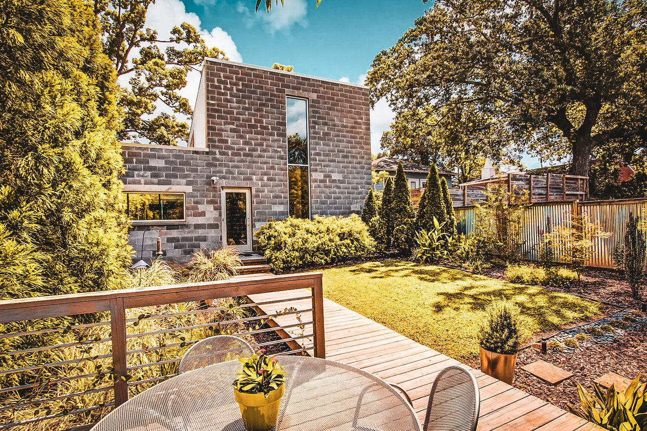 Outdoor living area with wooden decking and a block-style modern house at 490 Glen Iris.