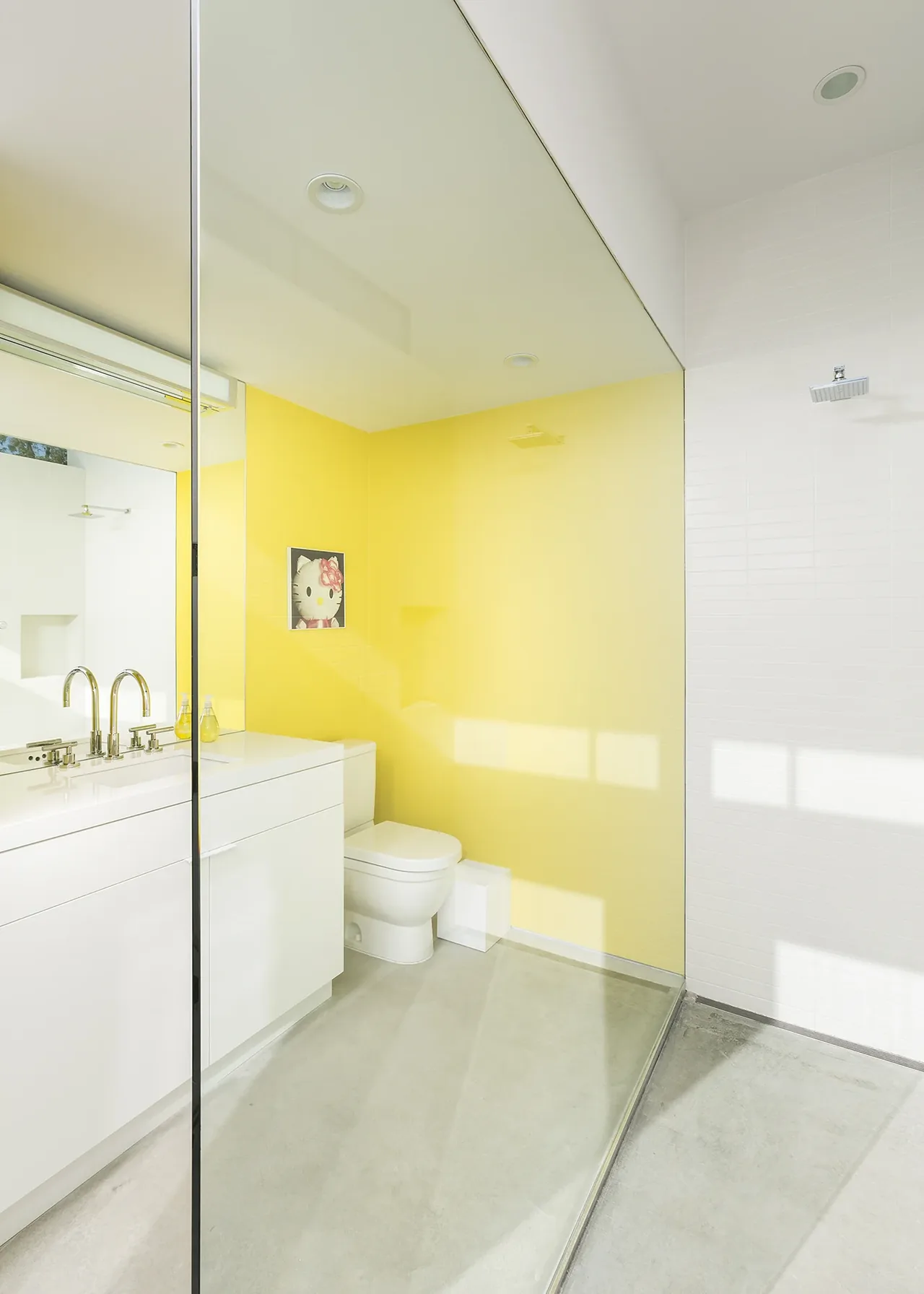 Bathroom featuring a yellow accent wall, white cabinetry, and a glass-enclosed walk-in shower with rainfall showerhead.