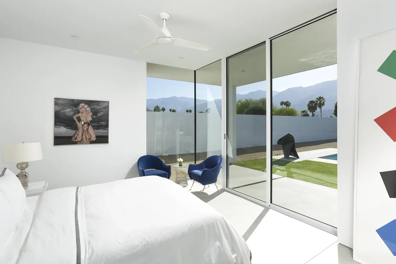 Bedroom in Palm Springs Residence with floor-to-ceiling glass doors and mountain backdrop.