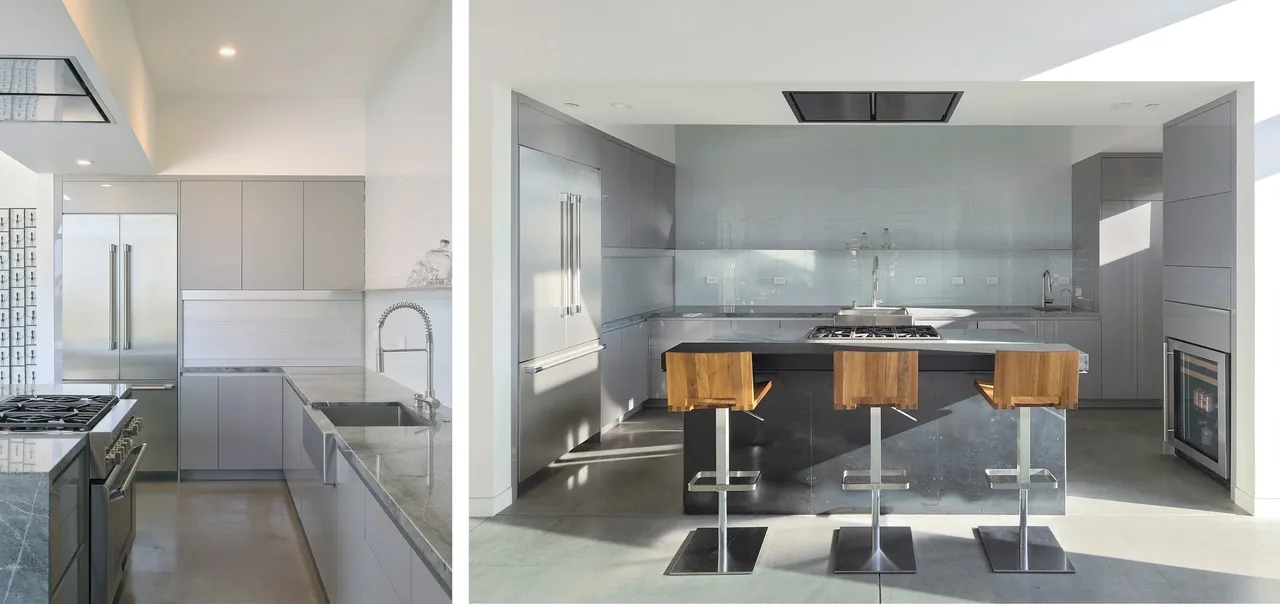 Modern kitchen featuring grey cabinets, a large island with wooden bar stools, and stainless steel appliances including a wine cooler.