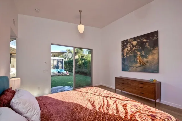 Bedroom with minimalist decor featuring a single bed and access to an outdoor garden view.