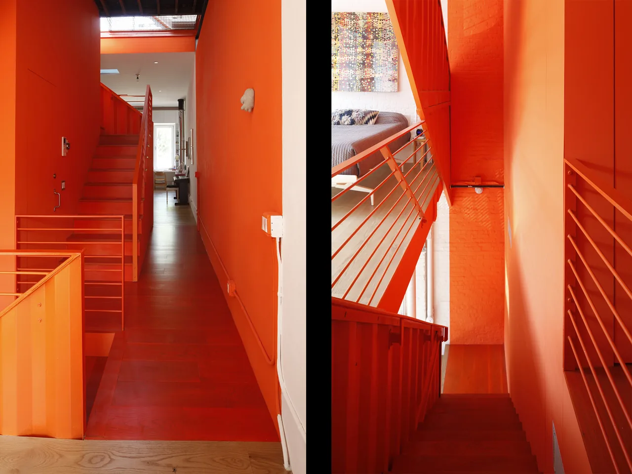 Staircase and hallway space featuring bright orange painted walls and metal stair railings.