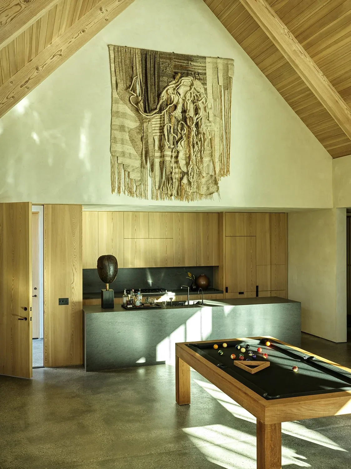 Canyon House kitchen with vaulted ceiling, wood cabinetry, and a pool table in the adjoining space.