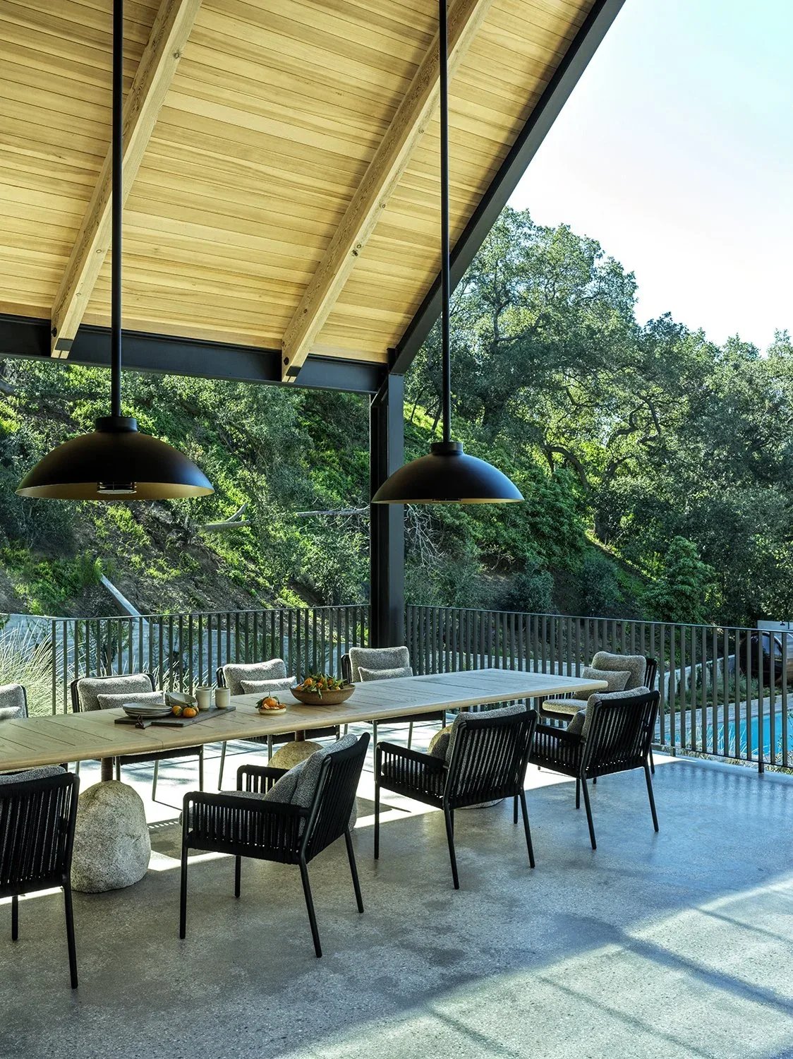 Outdoor covered patio dining area at Canyon House with wood ceiling and black pendant lighting.