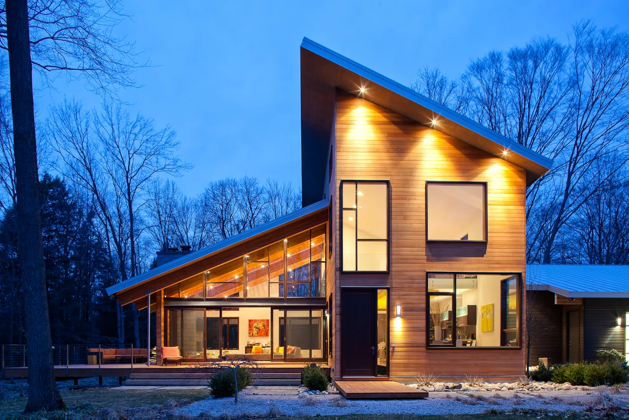 Pigeon Creek Residence features a modern angular facade with horizontal wood siding and prominent sloped roofs.
