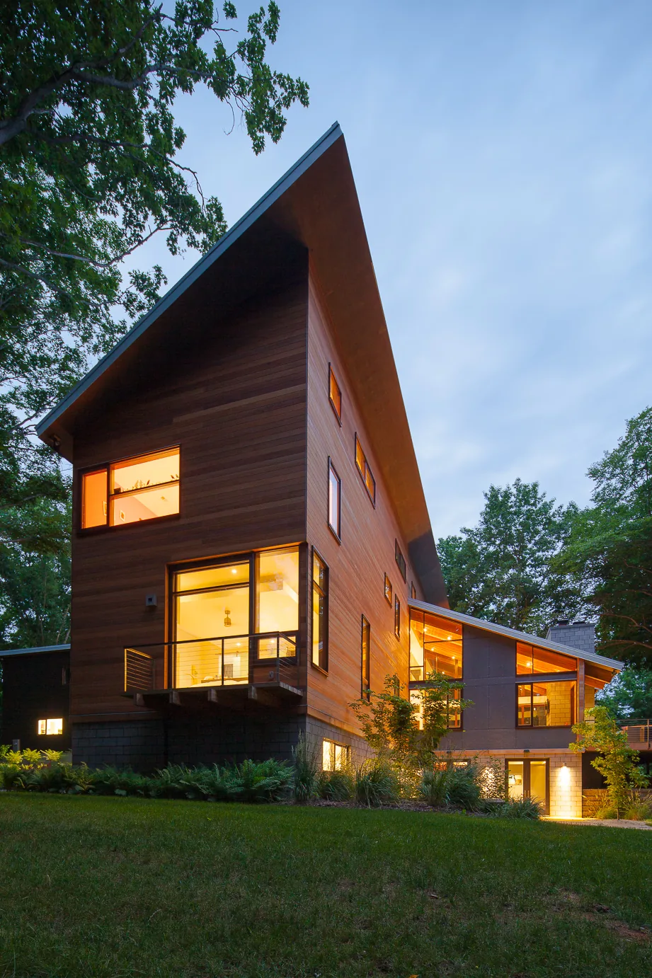 Pigeon Creek Residence features a steep angular roofline with large picture windows and a landscaped front yard.