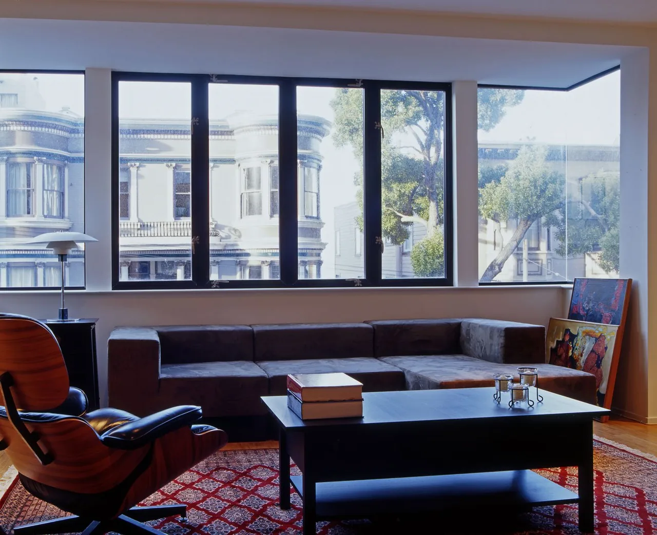 The Fisher Residence living room features a large window with views of a classic facade across the street.