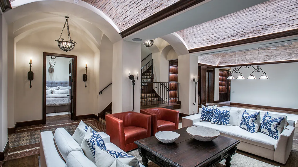 Spanish Colonial Revival living room with vaulted brick ceiling and mixed seating.
