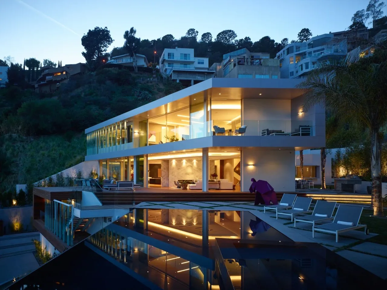 Rising Glen features extensive floor-to-ceiling glazing and a glass balcony railing on a steep hillside site.