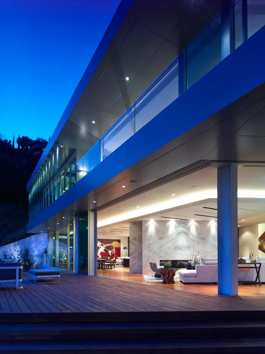 Rising Glen residence featuring glass balcony railing and open living space with marble accent wall, designed by MAKE Architecture.
