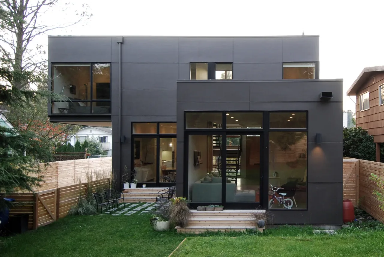 Greenwood House rear facade with large glazing and dark exterior paneling designed by Malboeuf Bowie Architecture in Seattle.