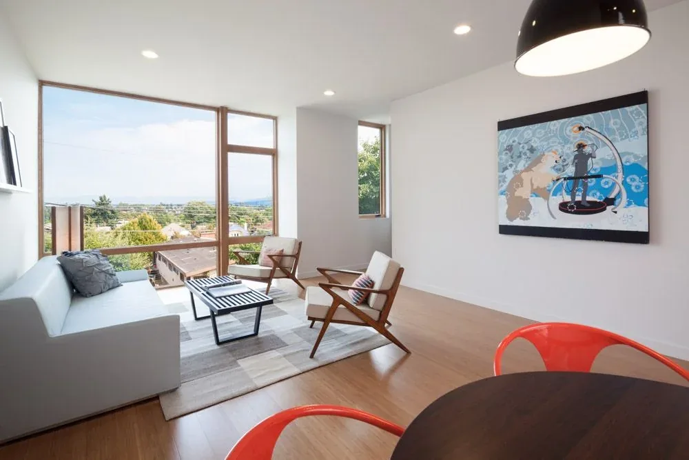 Living room features large vertical wood-framed windows offering expansive urban and mountain views.