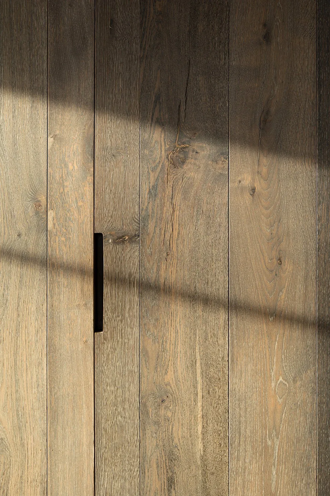 Natural wood planks with visible grain form a textured surface under soft lighting.