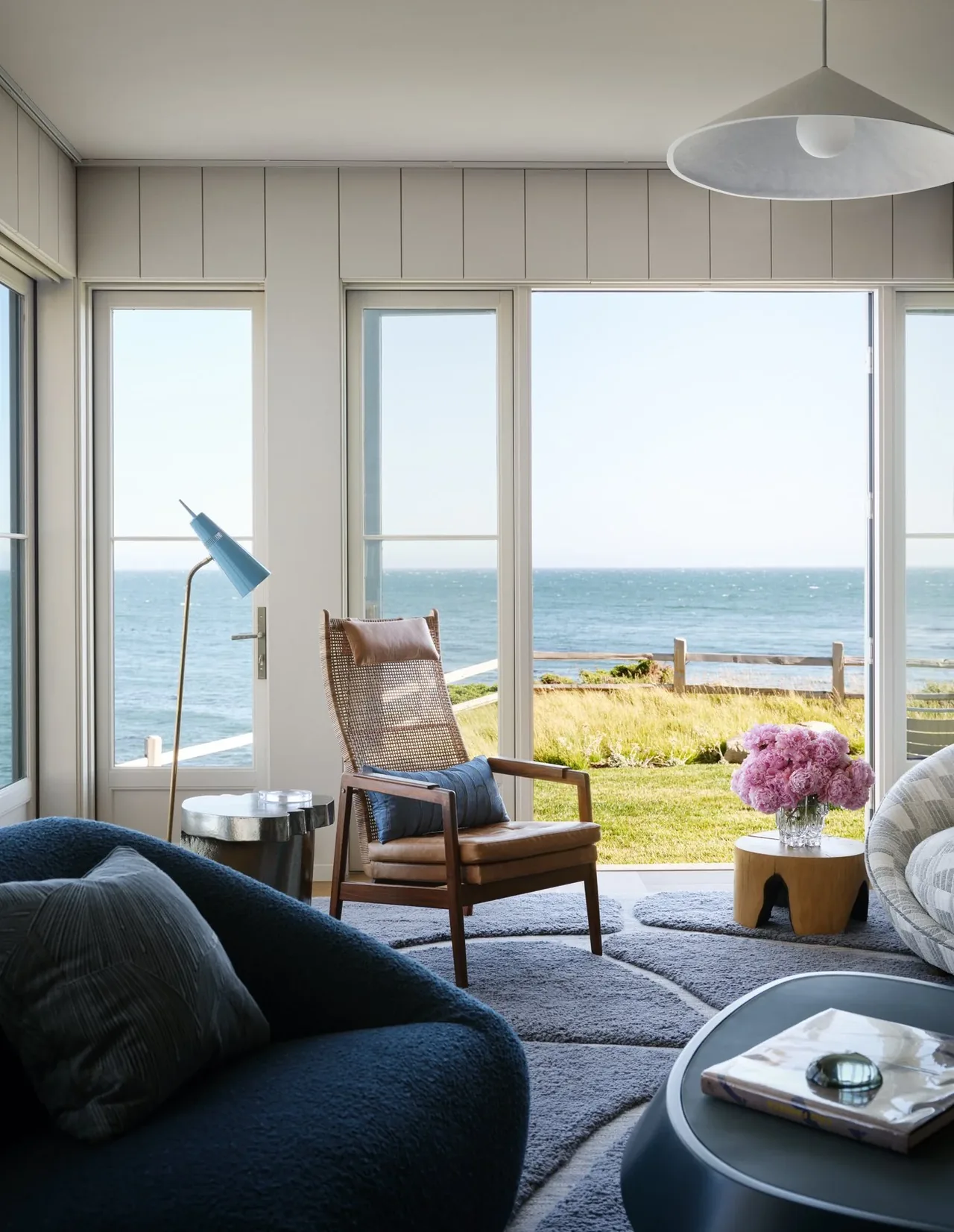Living room with floor-to-ceiling glass doors providing a clear ocean view at Pacific Promontory.