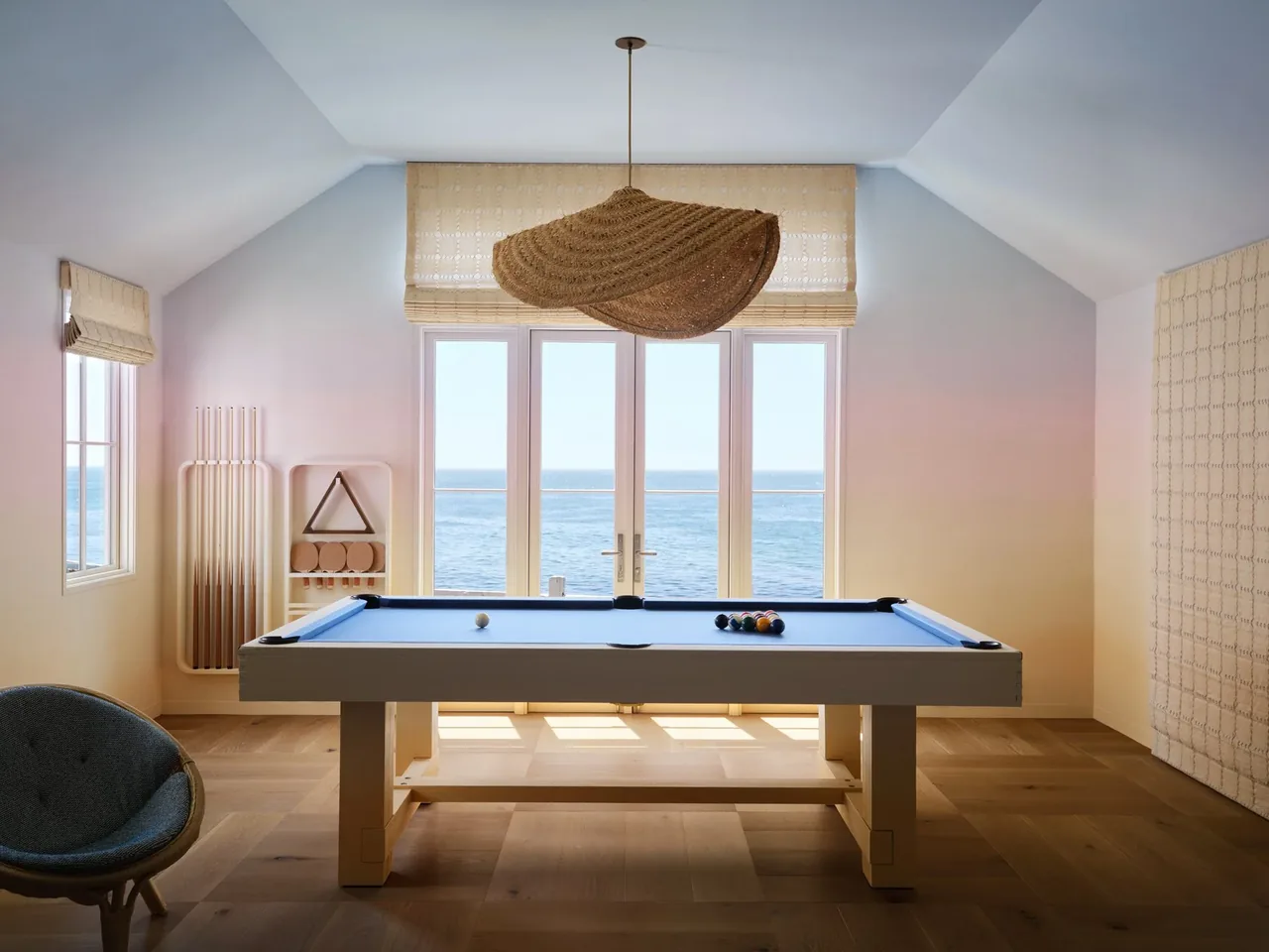 The Pacific Promontory game room features a pool table with an ocean view through large windows.
