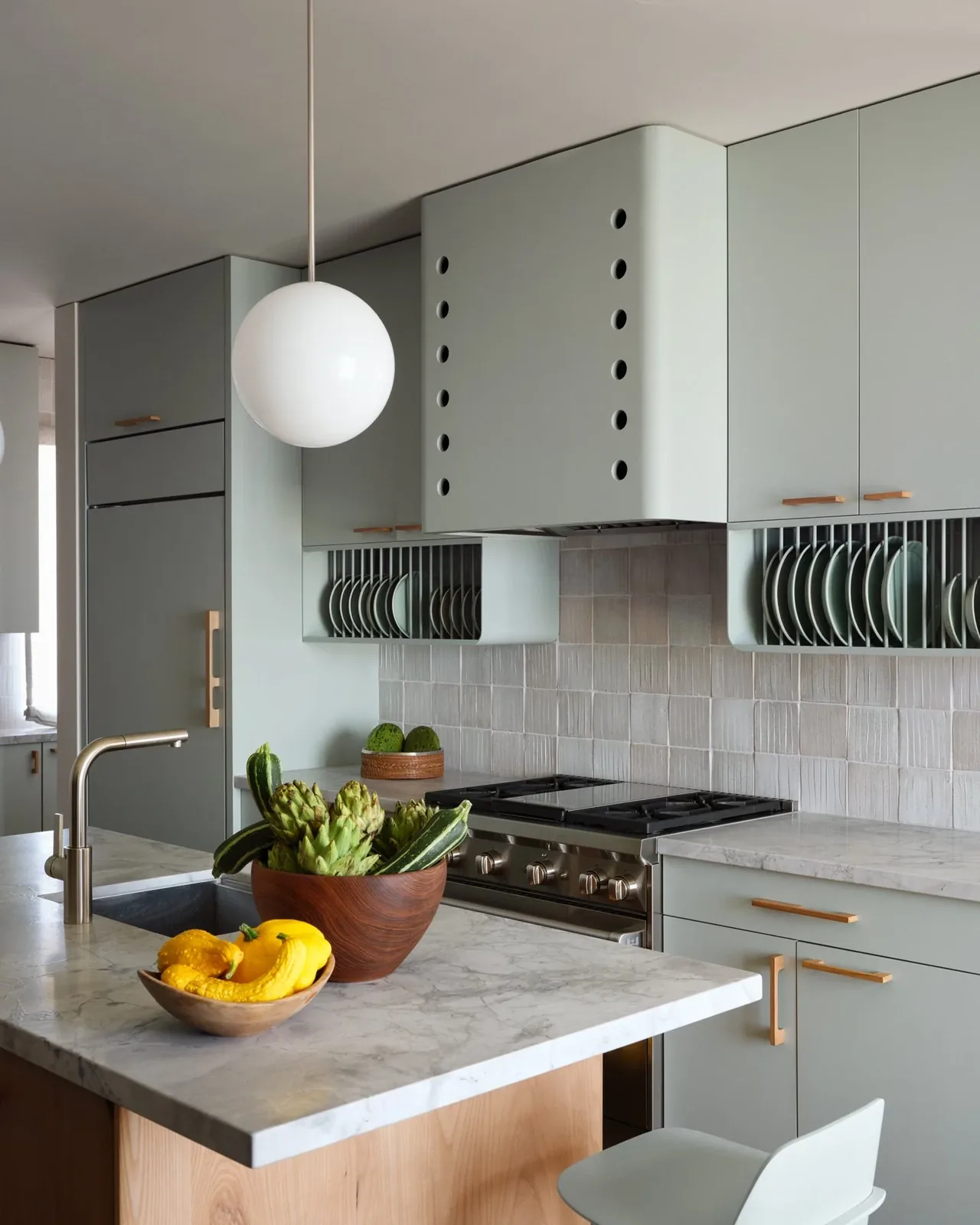 Kitchen features light gray cabinetry, marble countertops, built-in dish racks, and a stainless steel gas range.