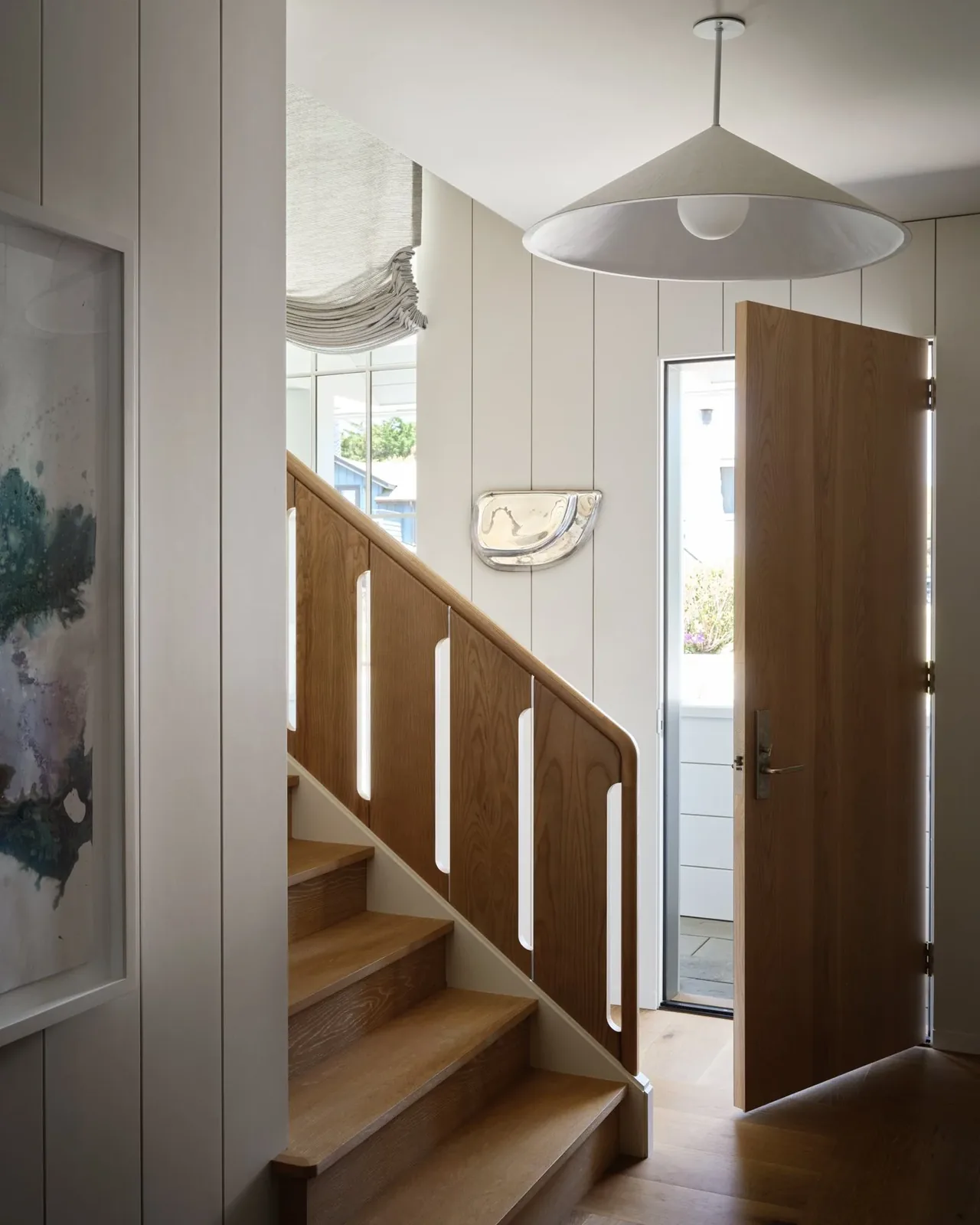 A simple wood staircase and open wood door in the Pacific Promontory house by McGriff Architects.