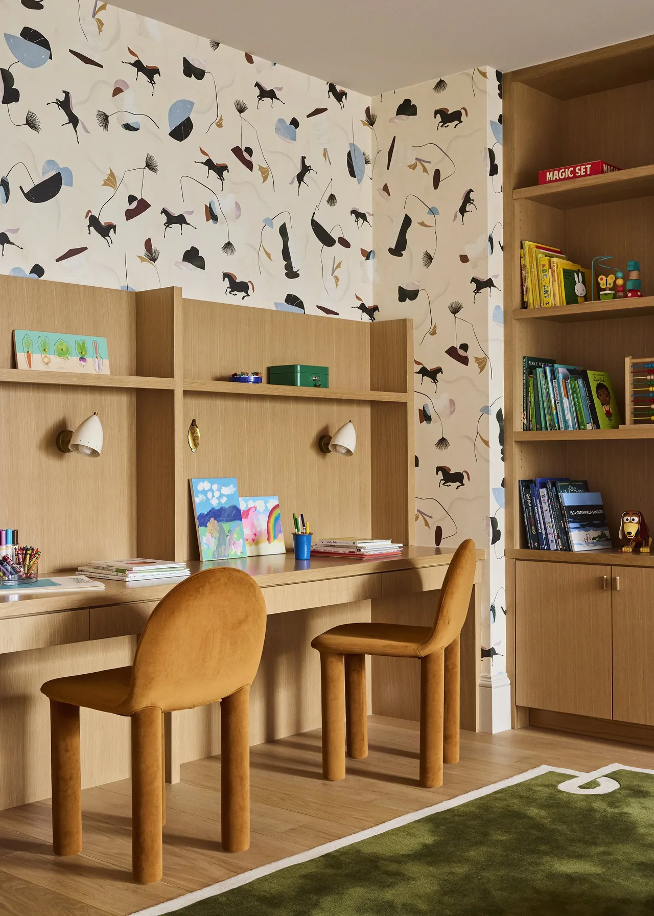Children's study area with custom wood desk, brown cushioned chairs, and whimsical horse-patterned wallpaper.