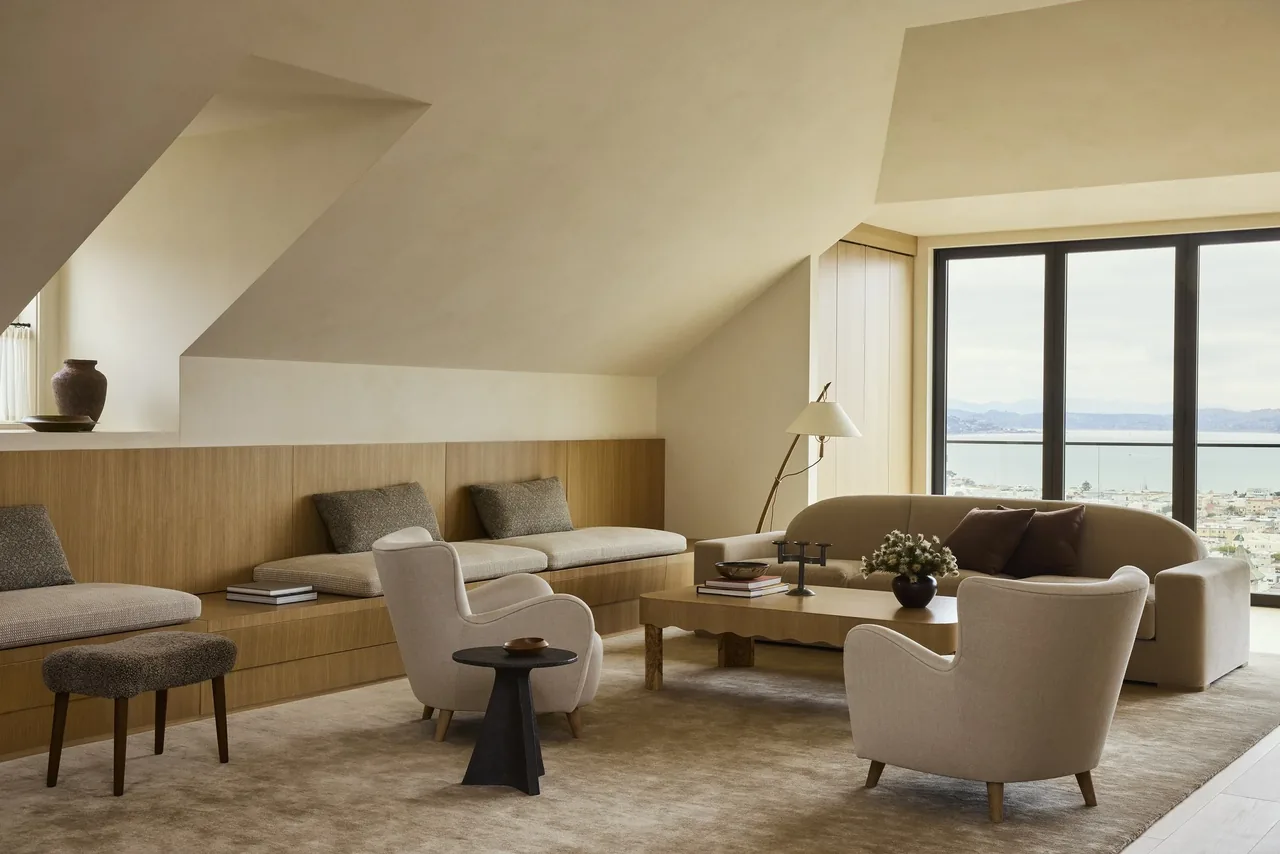 Living room with custom wood built-in bench seating and a large window overlooking the bay in the Modern Georgian Portrait project.