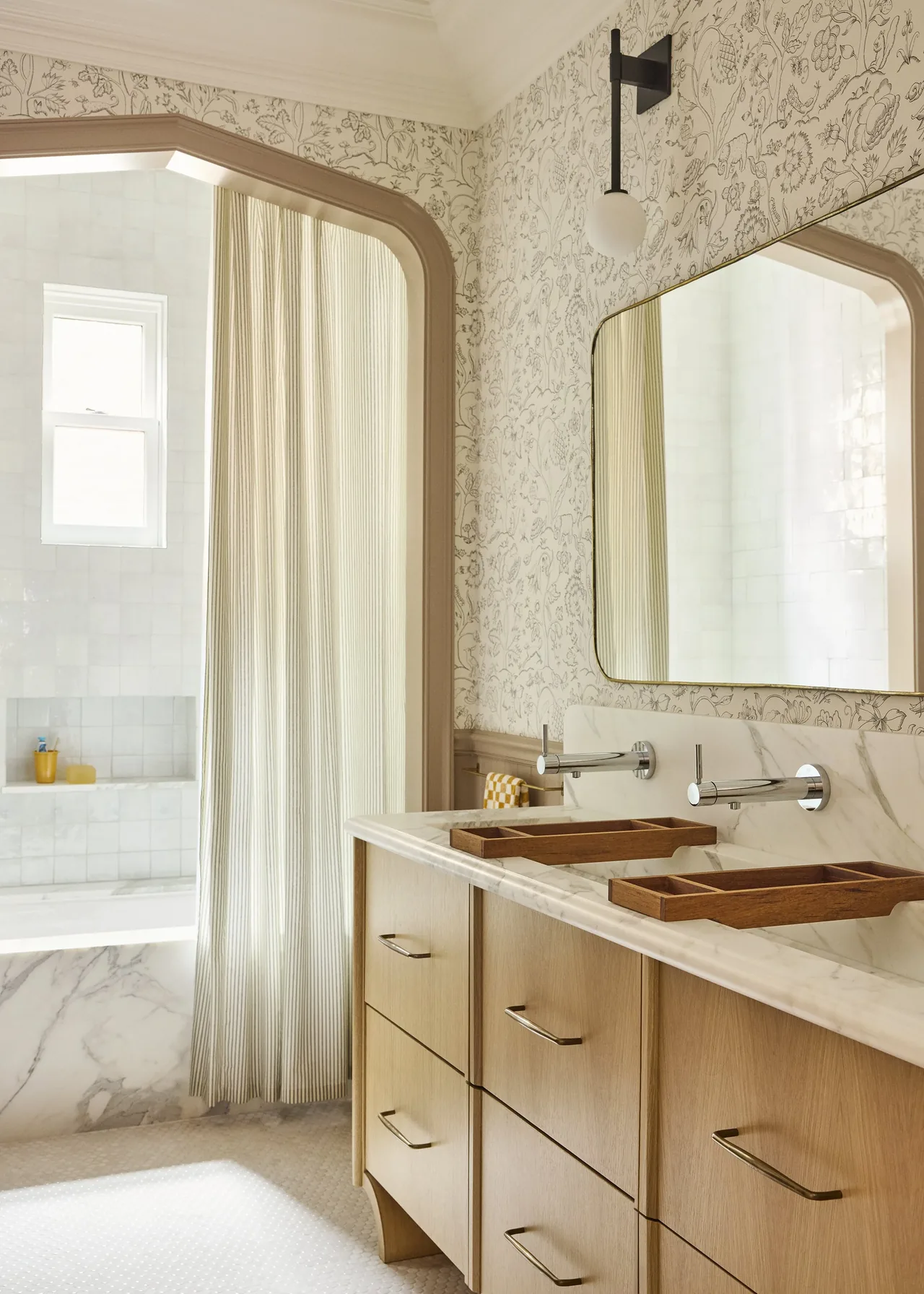 Modern Georgian bathroom features double vanity with wall-mounted faucets and floral wallpaper.