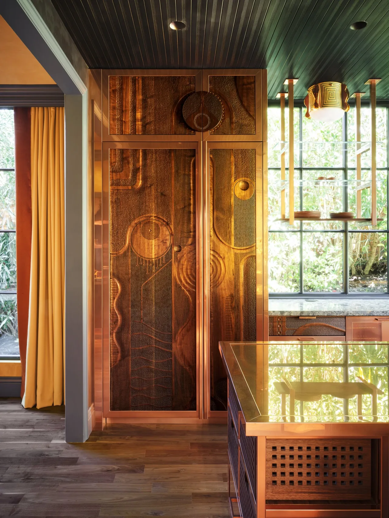 Copper cabinetry with textured panels and a reflective copper countertop kitchen island at Gallery House.