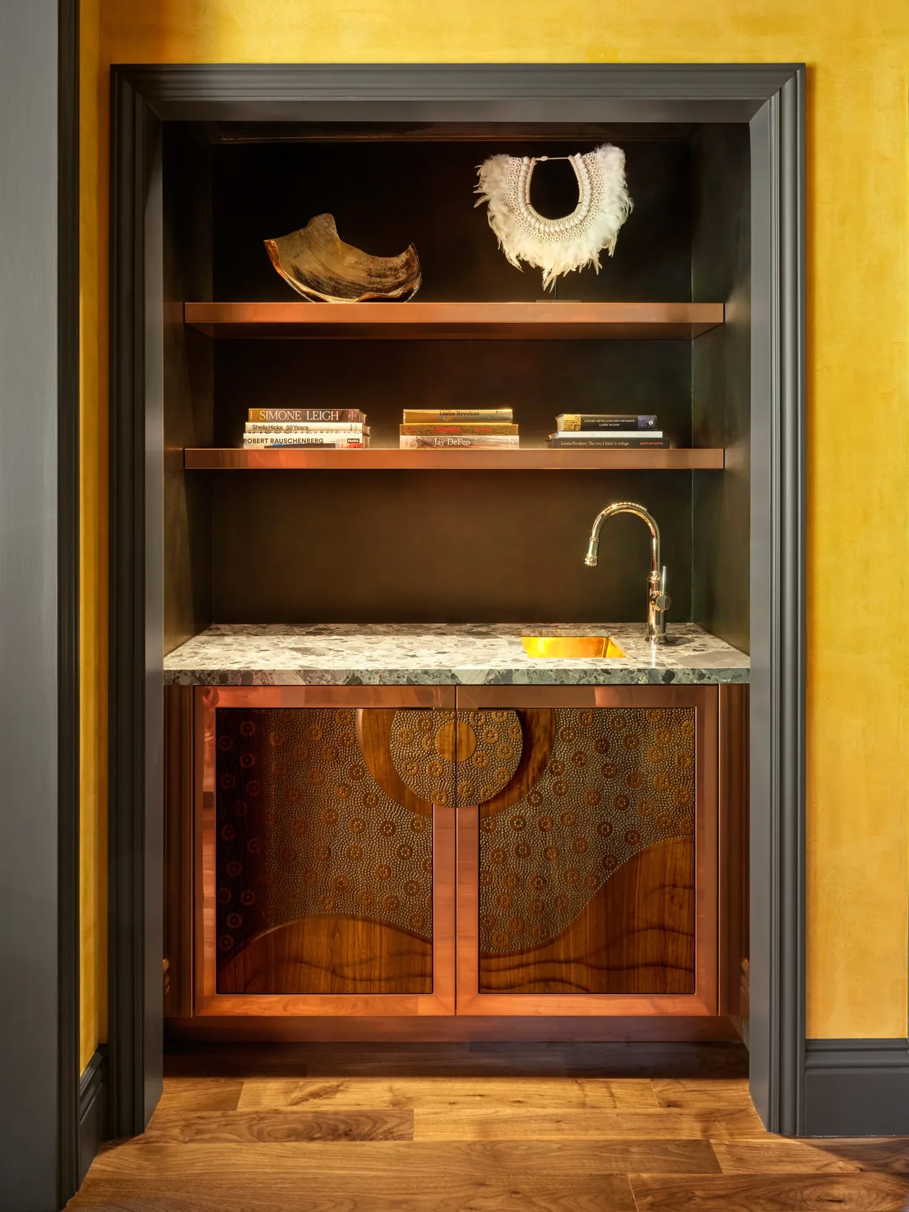 Gallery House wet bar features copper cabinetry with circular patterns and a stone countertop, designed by McGriff Architects.